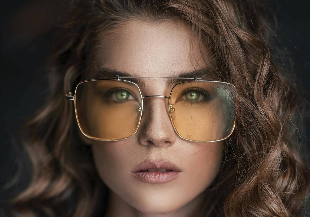 Close up of a woman wearing sunglasses with orange lenses